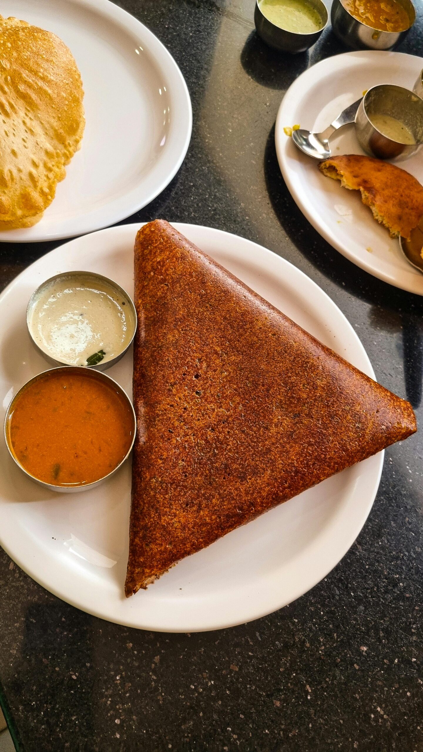 Delicious crispy dosa served with flavorful chutneys on a restaurant table in Dubai.